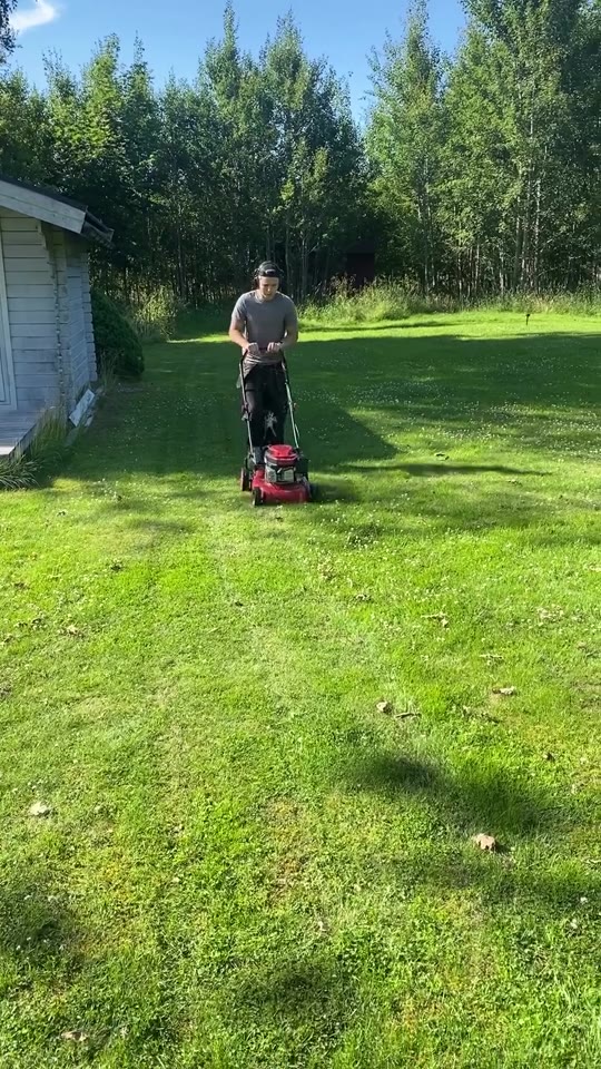 En medarbetare klipper gräset